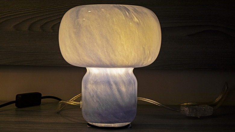 Closeup of a lit marble-colored vintage mushroom lamp