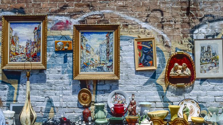 Vintage paintings and secondhand objects against graffiti.