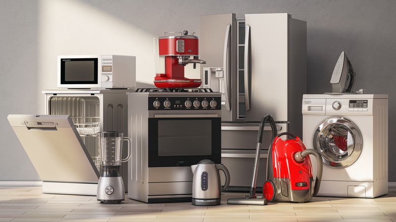 A variety of home appliances, including a dishwasher, microwave, oven, fridge, washing machine, vacuum, and iron