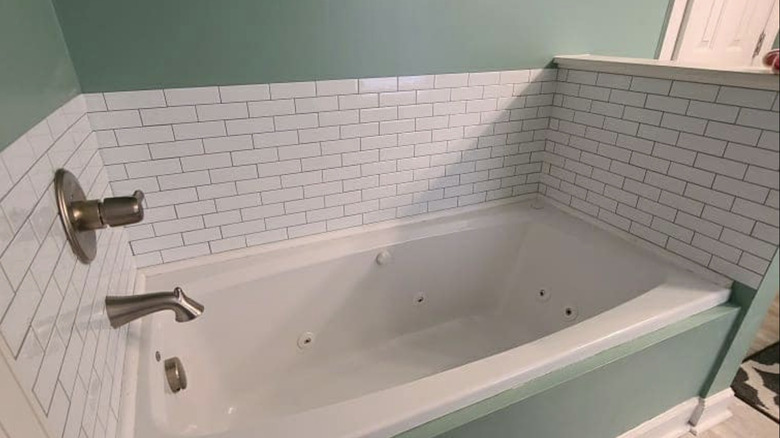 A tub's wall finished with Aldi tile