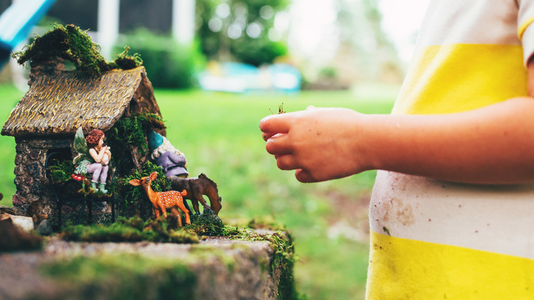 Person building a fairy garden