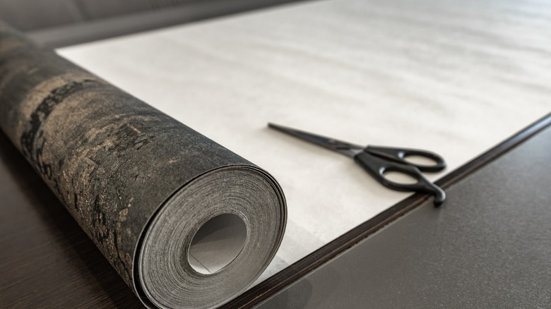 Roll of peel and stick vinyl with scissors sitting on top, ready to be cut