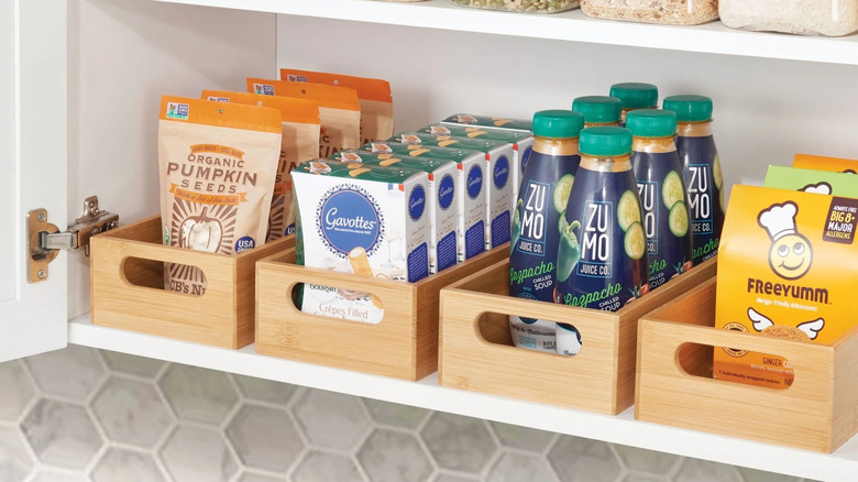 A row of bamboo boxes, filled with pantry staples on a shelf