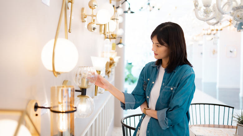 Woman looking at wall sconces at the store