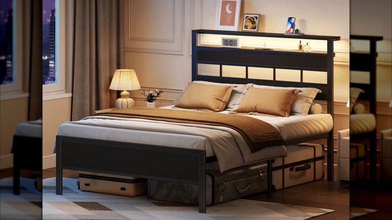 modern bedroom with neatly made bed, mood lighting, and suitcases stored underneath