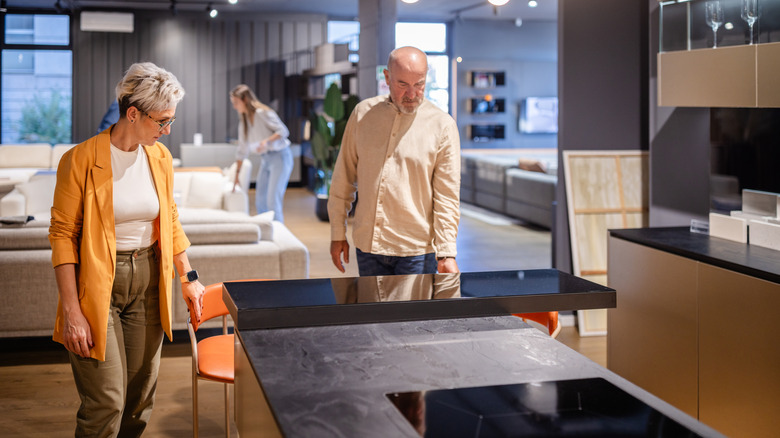 A couple looks at a showroom's kitchen setup