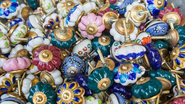 A pile of different colored ceramic door knobs