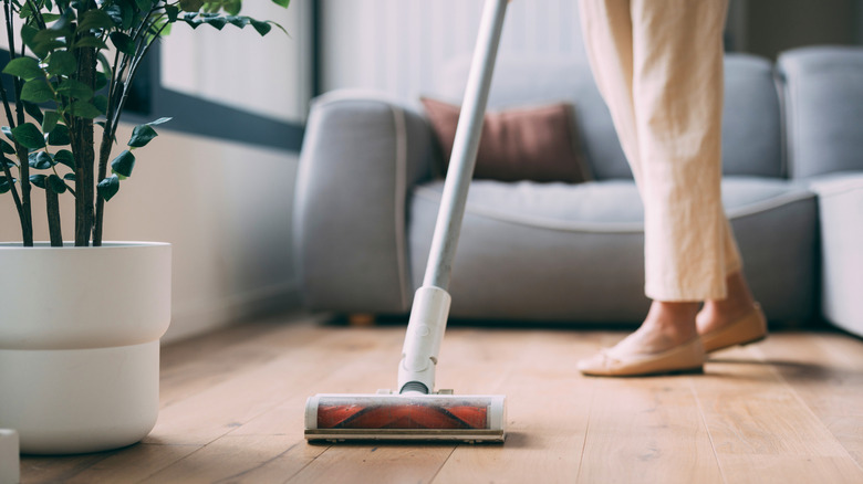 Woman vacuuming hardwood floor