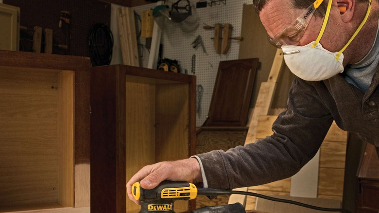 DeWalt's corded sander in use on a cabinet door