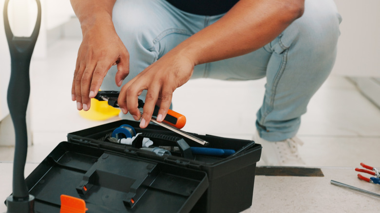 Person grabbing tools from a toolbox