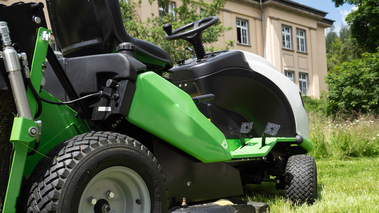A green riding mower in a garden