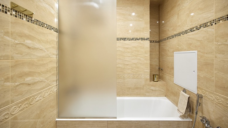 Frosted glass shower panel in beige bathroom