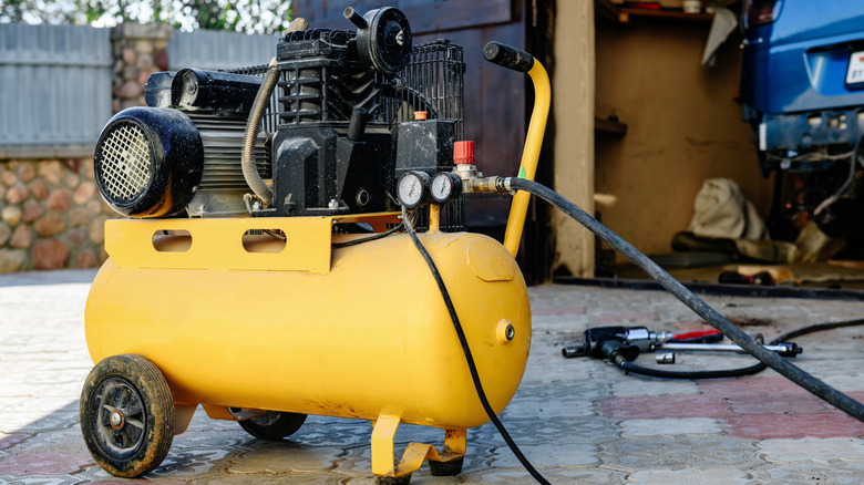 Person using an air compressor while working on a car