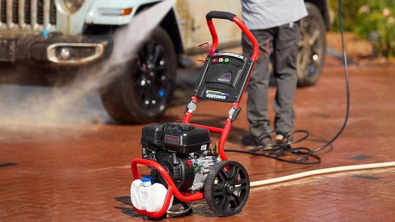 A person power washing a Jeep