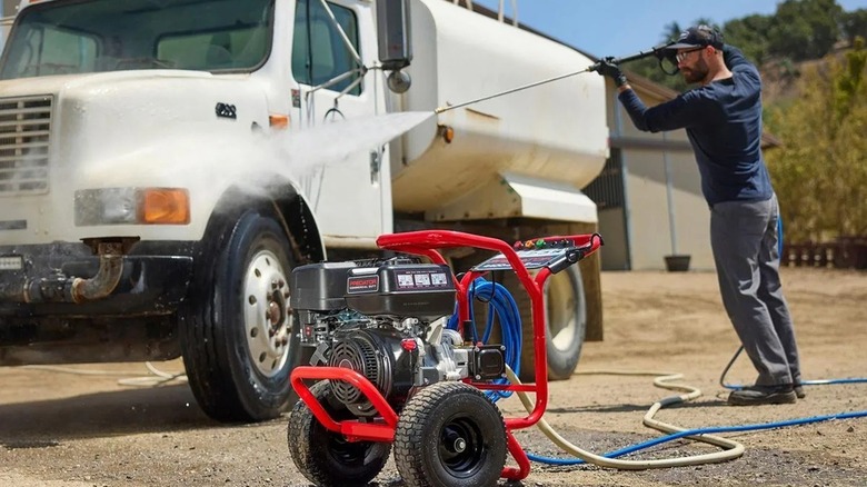 A man power washing a commercial truck
