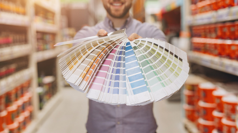 Man holding paint swatches in home improvement store