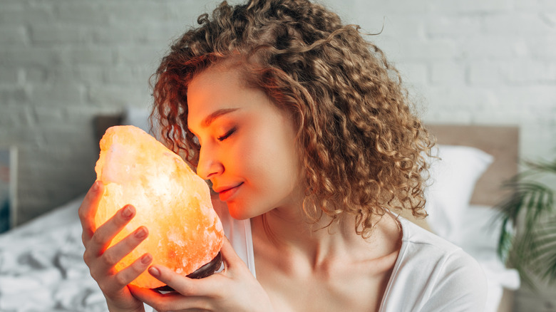 woman holding himalayan salt lamp