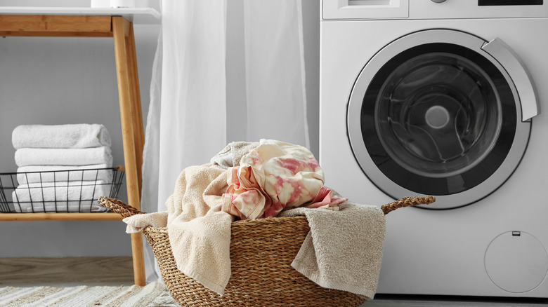 laundry in a basket next to a washing machine