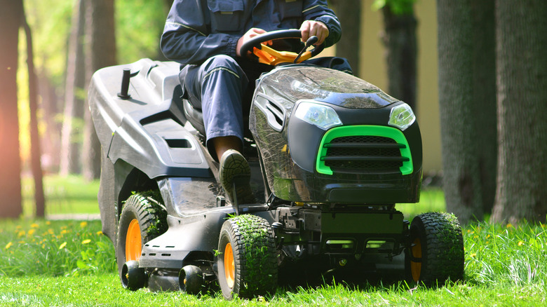 person cutting the grass with riding mower