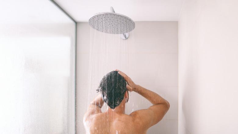 man under rain shower head