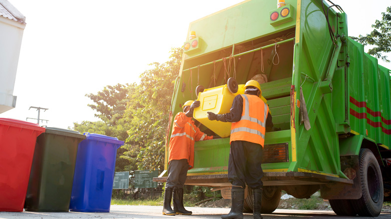 People emptying trash can