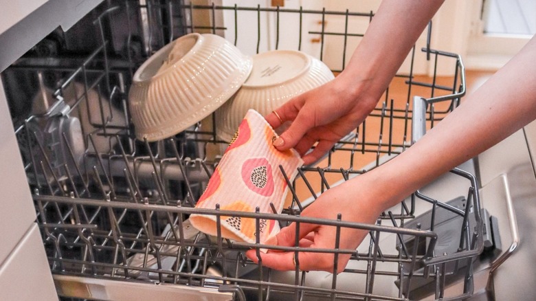 Person putting reusable paper towel in dishwasher