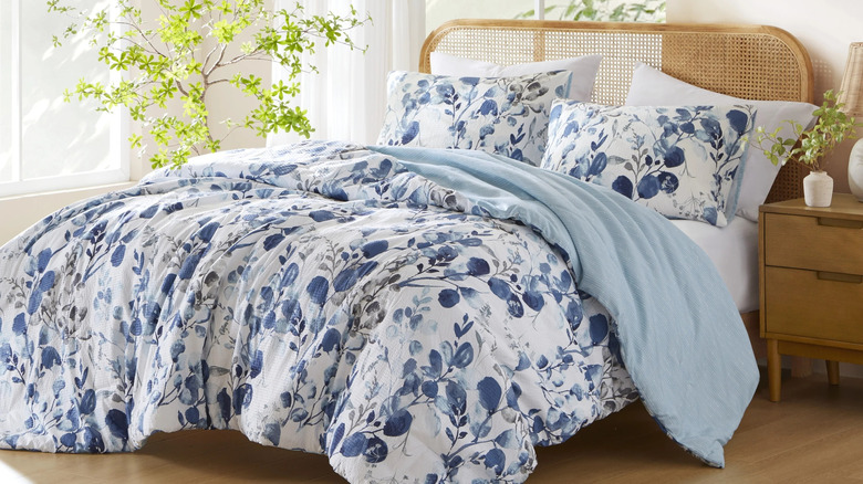 A blue-themed reversible comforter with flowers on one side