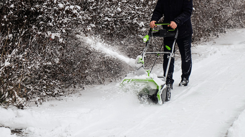 A cordless electric snow blower in action