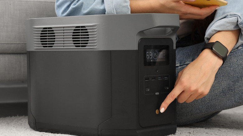 A person turning on a portable power station at home