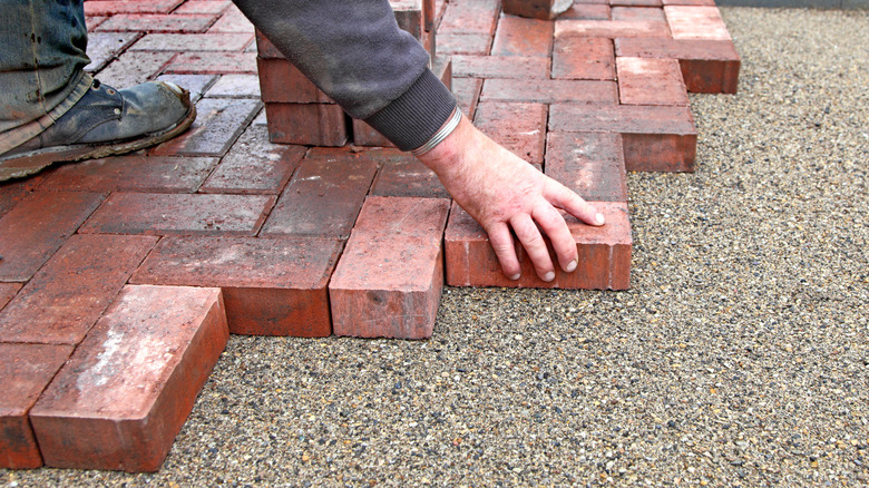 Person laying brick flooring