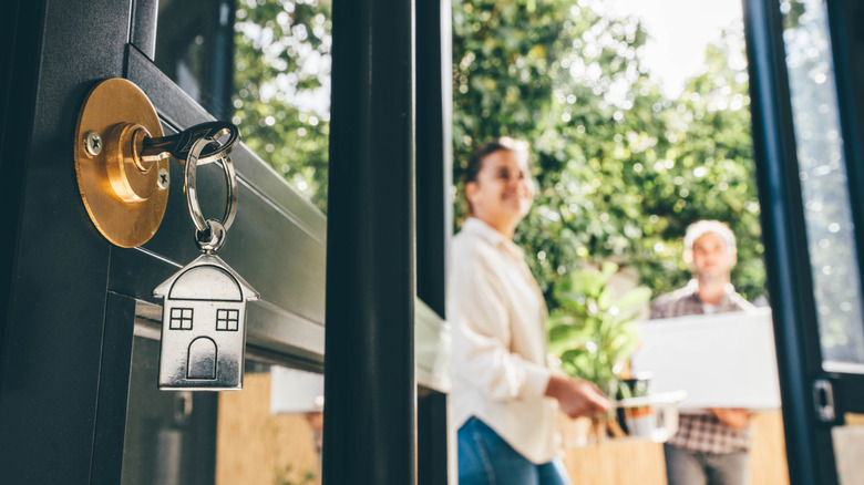 couple moving into new home with close up of keys in front door