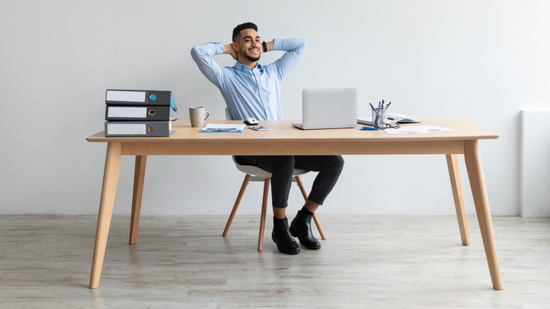 man reclining on desk chair