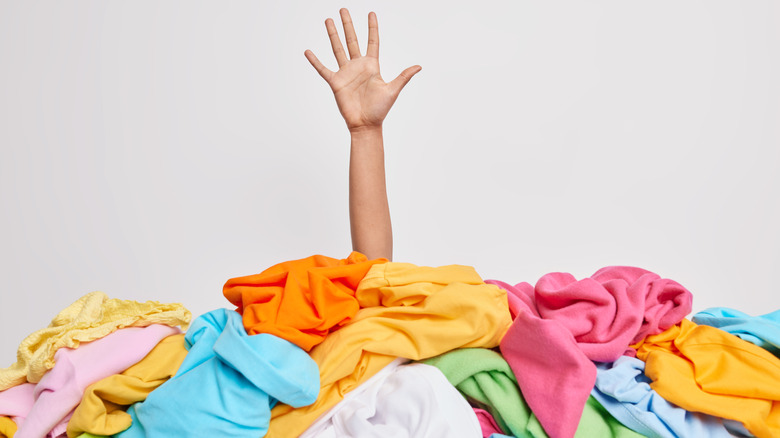 Pile of clothing with hand