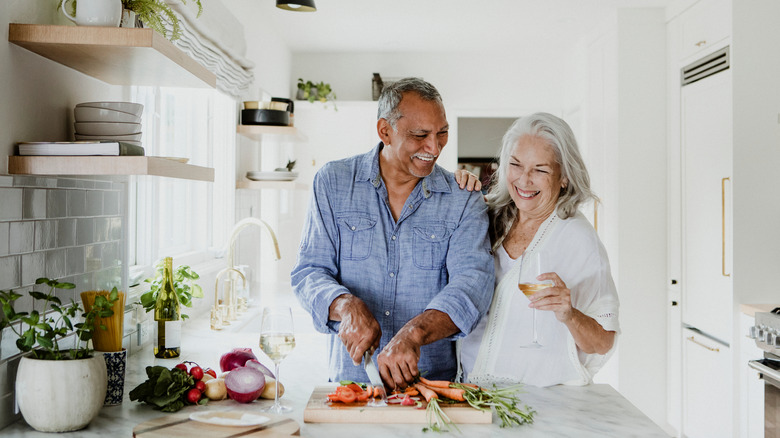 couple happily cooking in kitchen