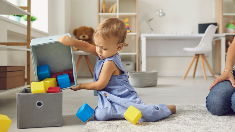 baby playing with parent in nursery