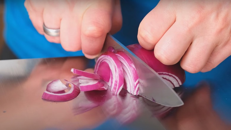Person cutting onions on titanium cutting board
