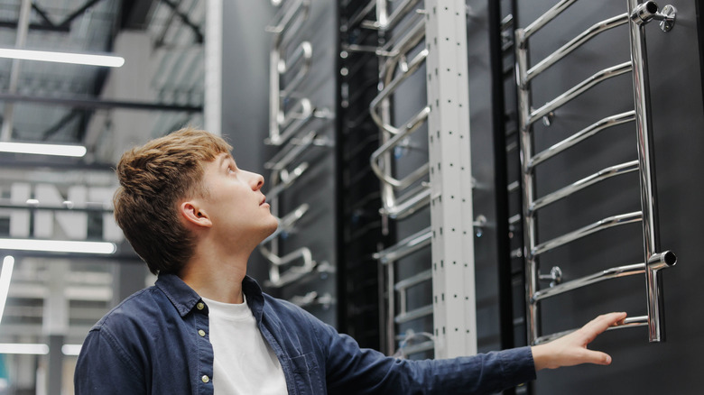 a man looks at towel warmers in a store