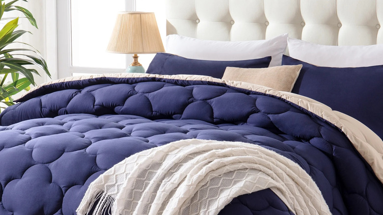A navy blue Yalamila comforter is shown on a large bed