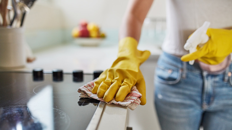 Person sanitizing countertop with gloves