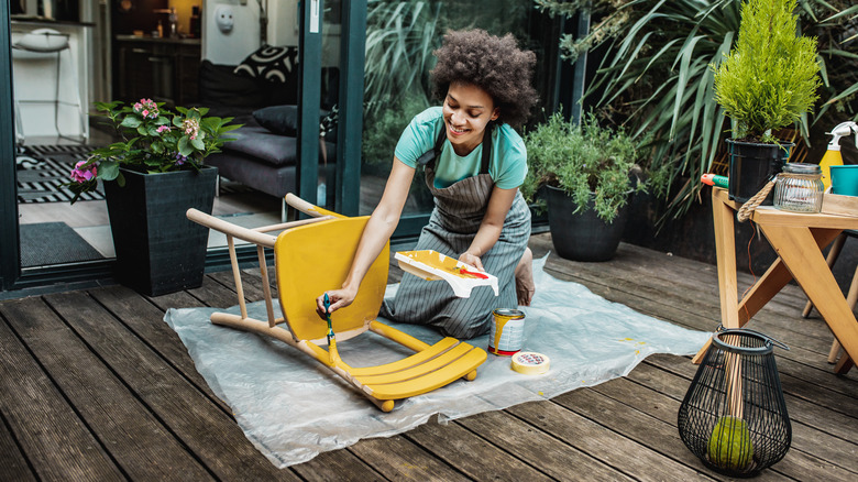woman painting a chair