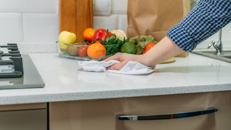 Person cleaning marble countertop