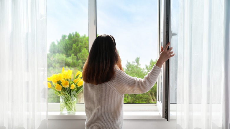 woman opening a window