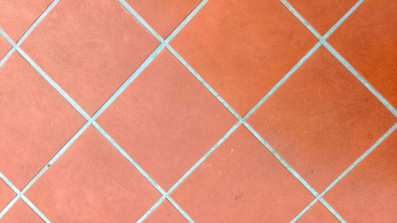 Red floor tiles with white grout lines