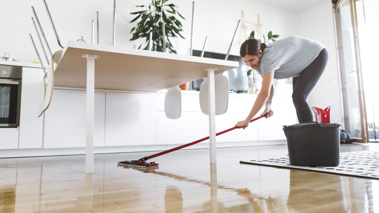 Woman cleans shiny wood floor