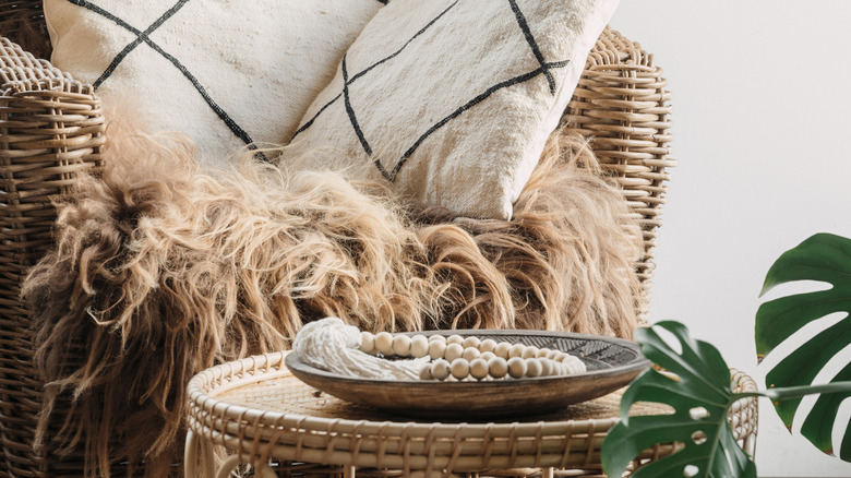 Wooden beads in tray on top of woven side table.
