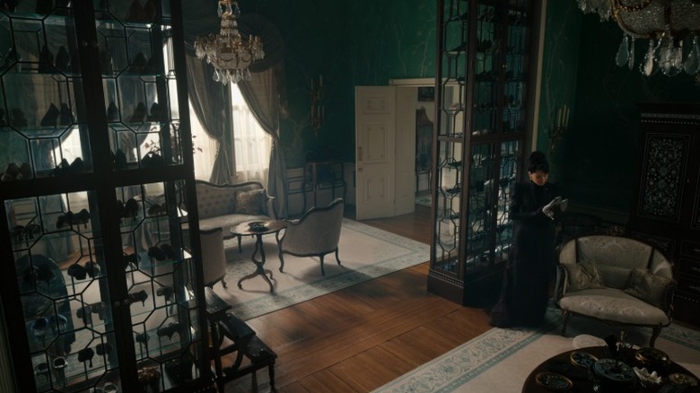Lady Araminta Gun inspects a pair of silver heels in her large closet with glass cabinets.