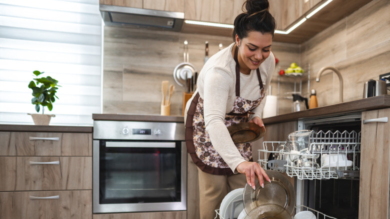 Woman loading a diswasher