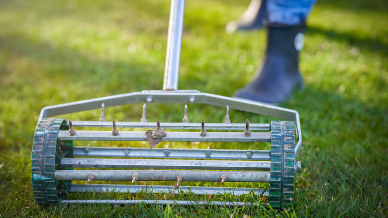 A person using a grass aerator on a lawn
