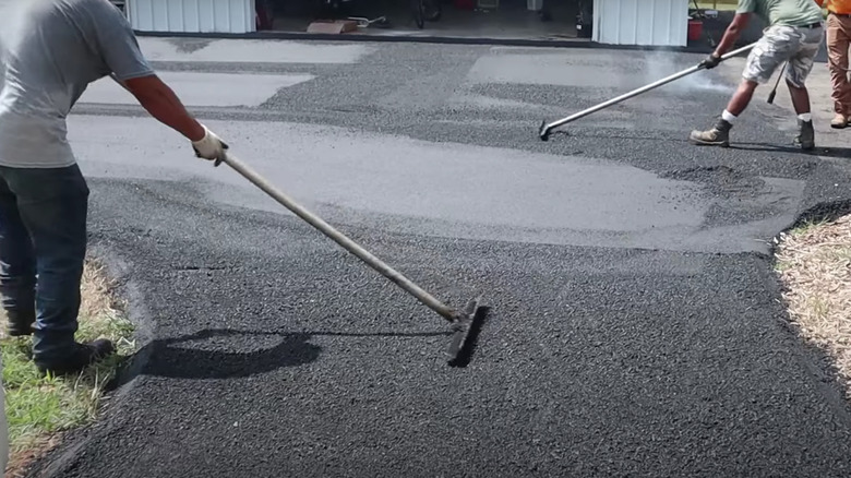 Workers installing asphalt driveway