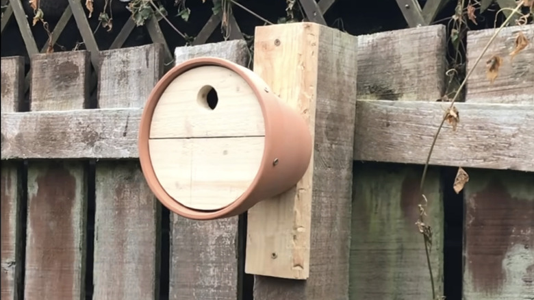 A DIY birdhouse made from a terracotta pot.